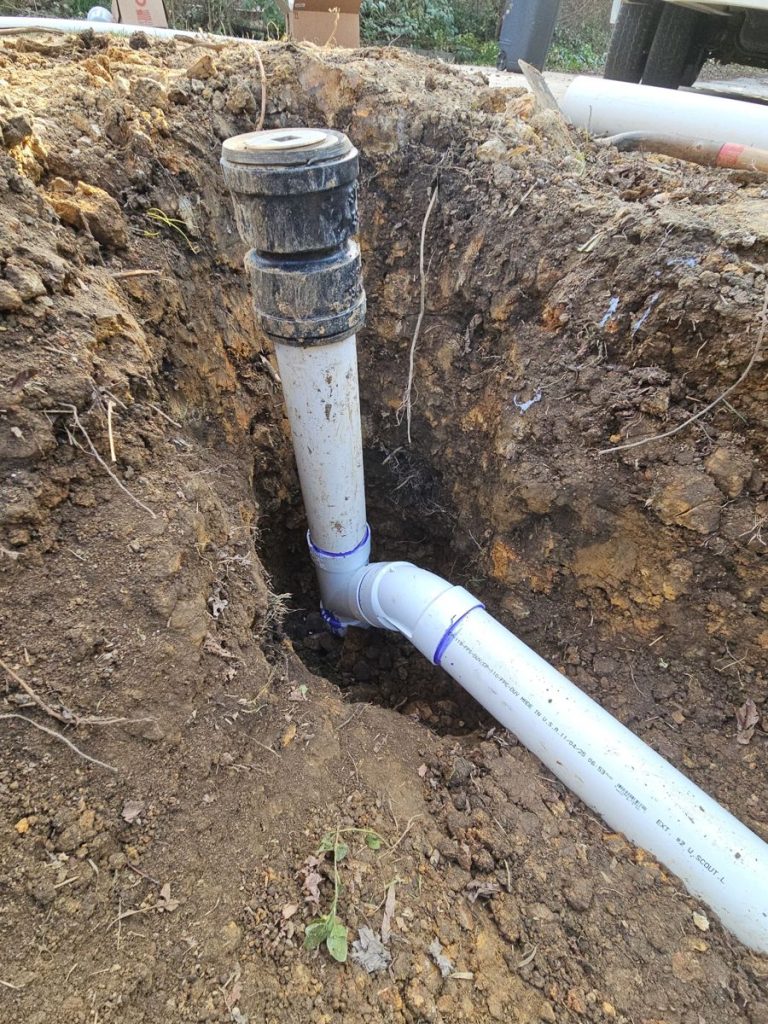 New PVC sewer line connection with a cleanout riser installed in the trench