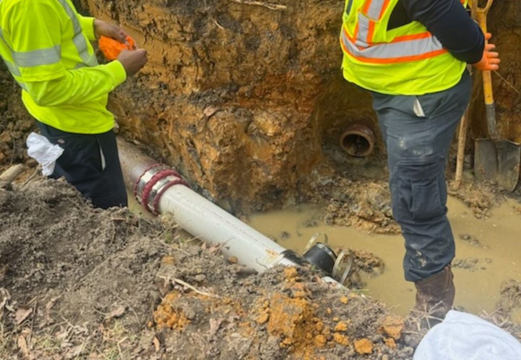 Crew excavating around a sewer line during a sewer line replacement in the Greensboro NC area