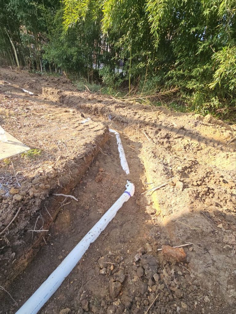 New PVC sewer line with an elbow turn in an excavated trench