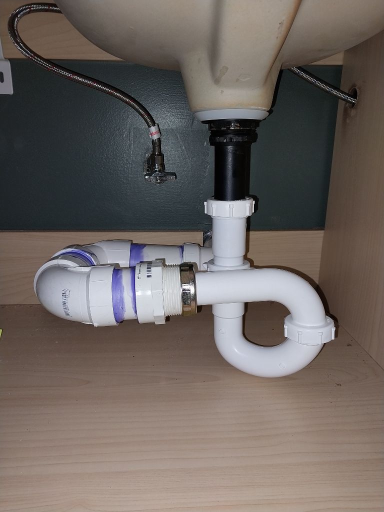 Drain line and P-trap under a bathroom sink in a Greensboro-area home